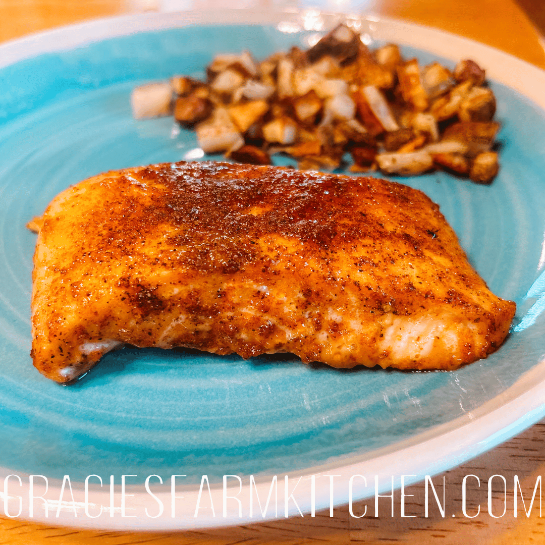 Cooked salmon and crispy potatoes on a blue plate.