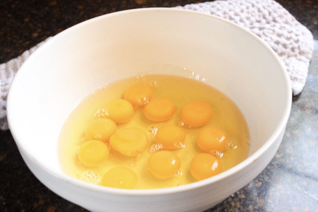 Eggs cracked in a bowl for a high protein breakfast casserole.